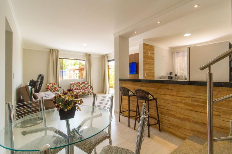 Sala de jantar com mesa de vidro e balcão