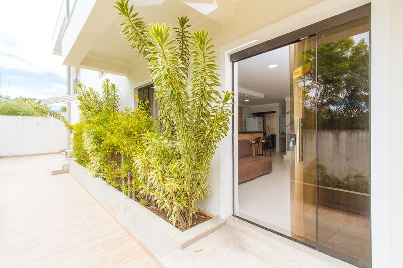 Entrada de uma casa com porta de vidro e plantas