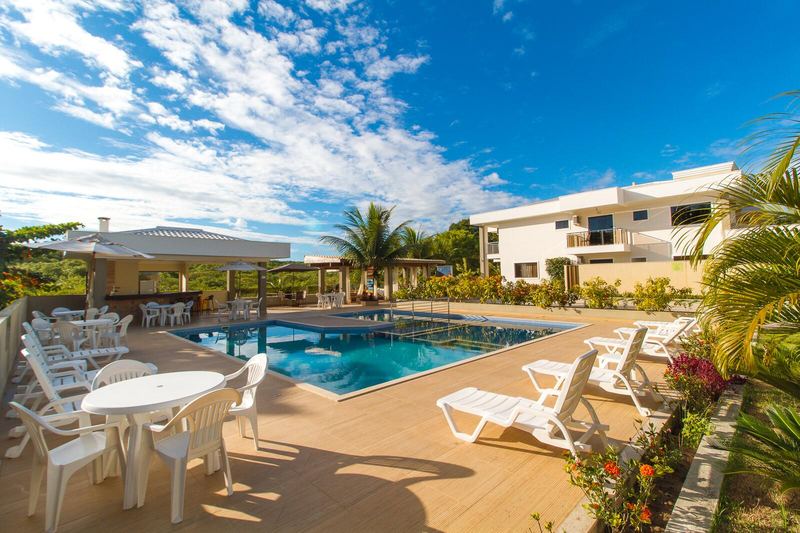 Mesas e espreguiçadeiras em volta da piscina