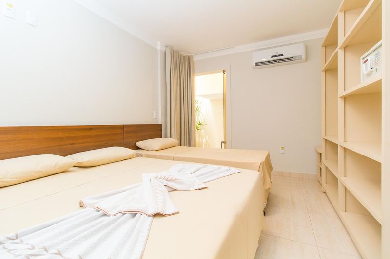 Quarto com camas arrumadas e armário