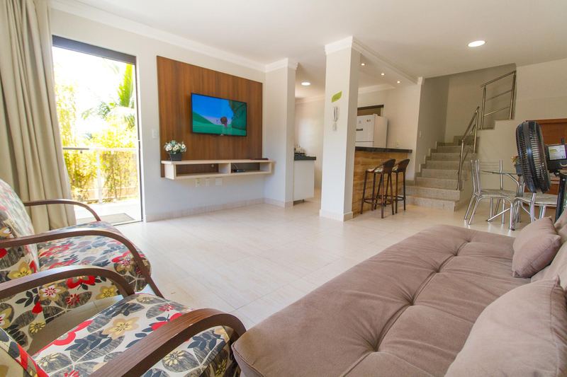 Sala de estar com sofá, TV e escada