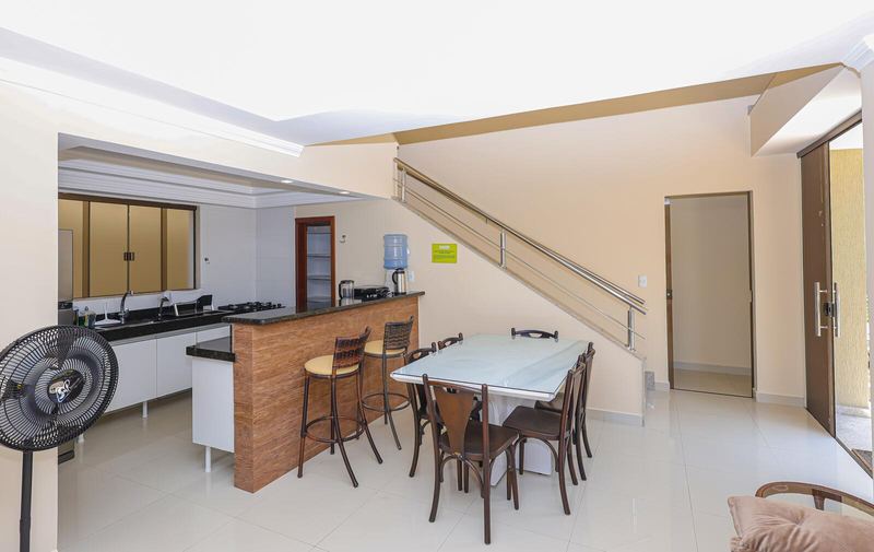 Cozinha com balcão e mesa ao lado da escada