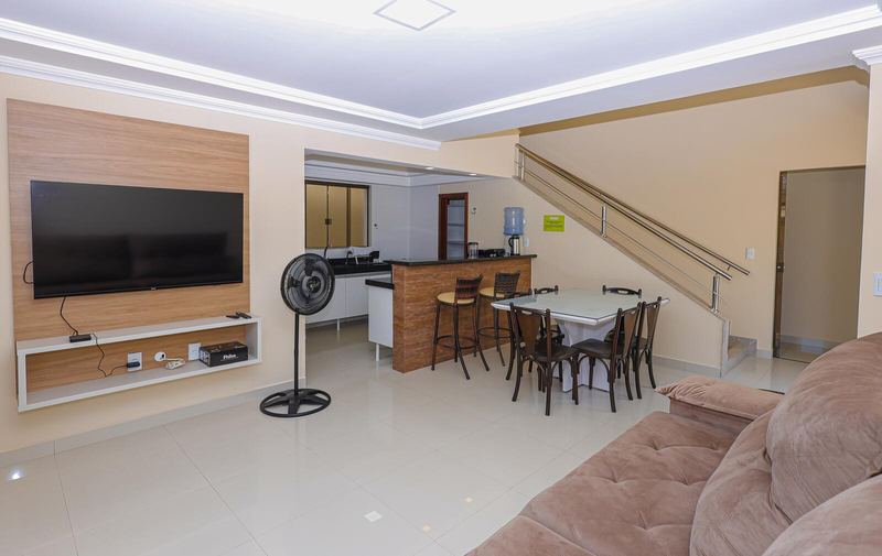 Sala com TV, escada e cozinha